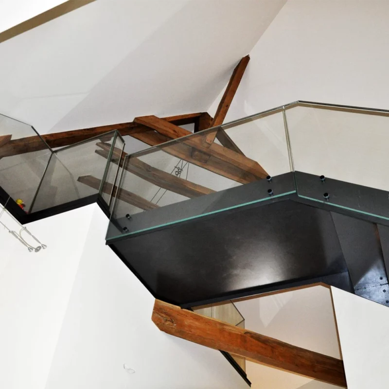 Un escalier de verre et d'acier, qui s'associe parfaitement avec l'âme du lieu